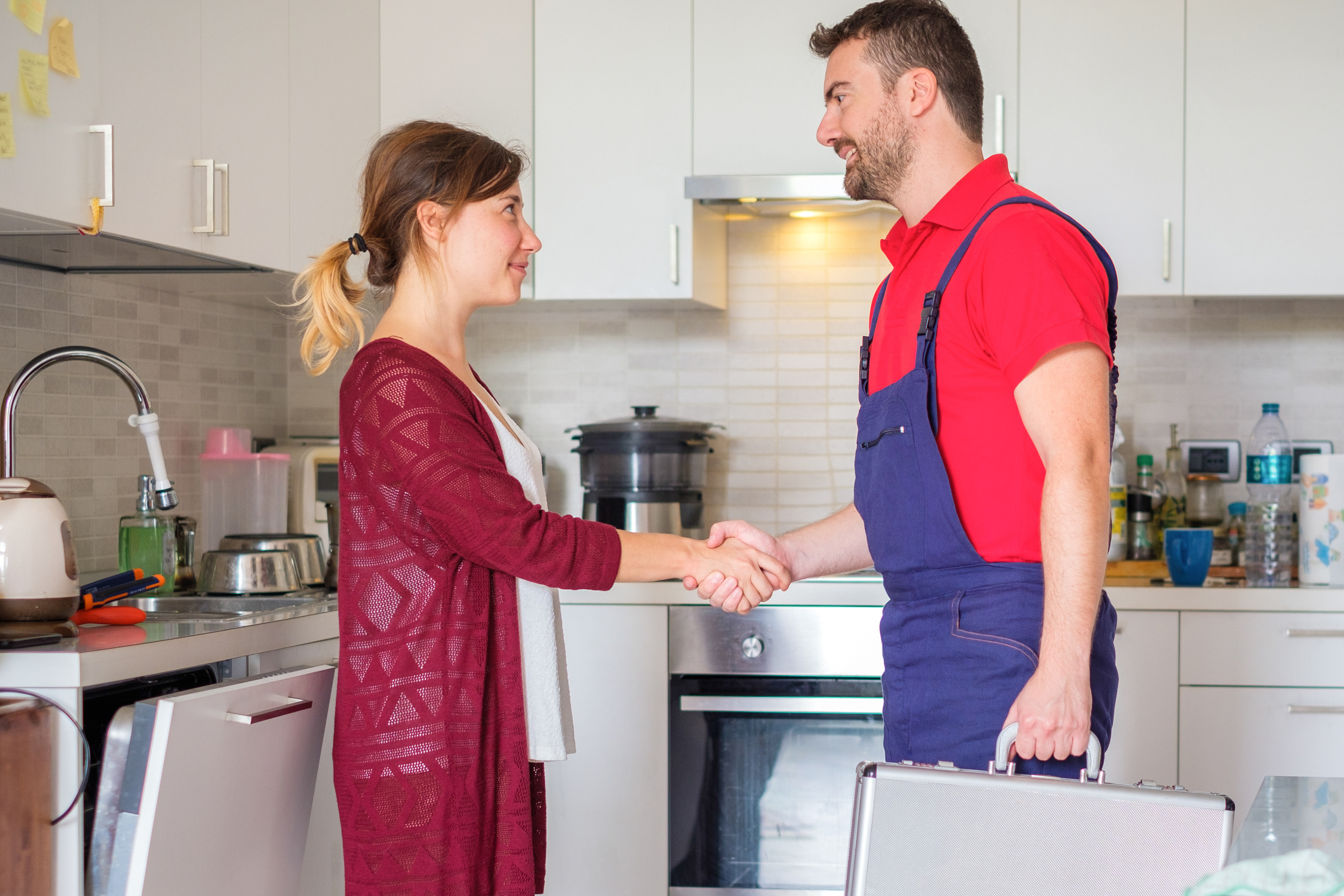 woman and appliance repair man shaking hands