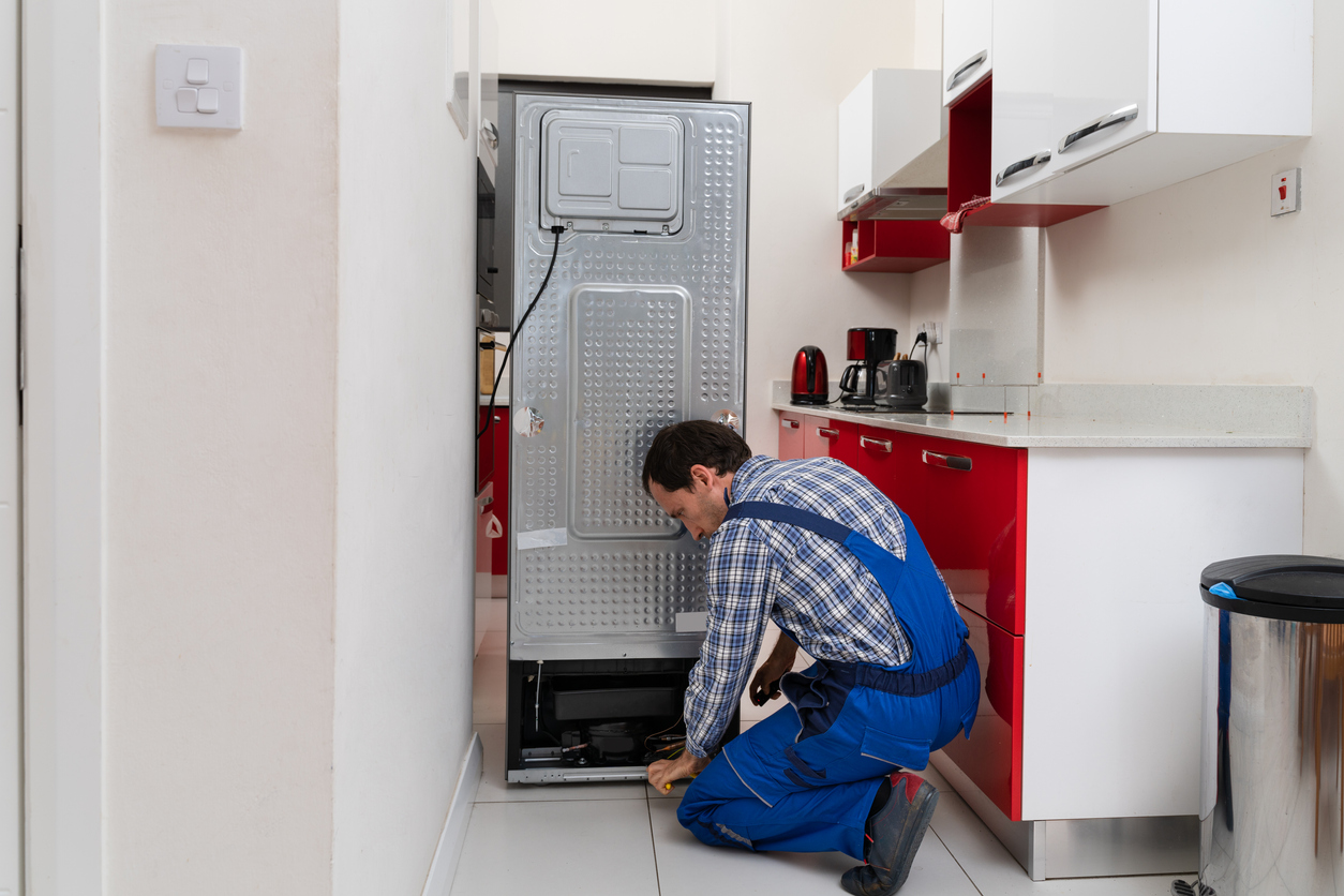 repairman fixing fridge